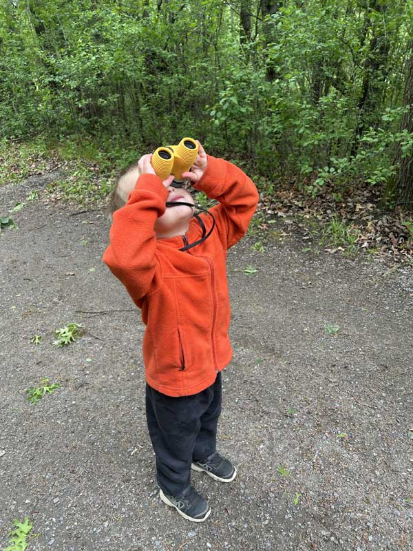 Photo of child looking through binoculars.